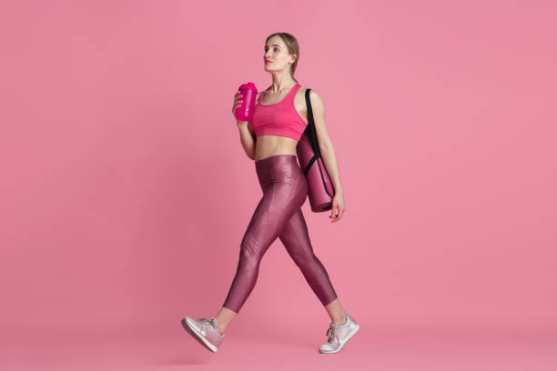 istock Beautiful young female athlete practicing on pink studio background, monochrome portrait 1220360258