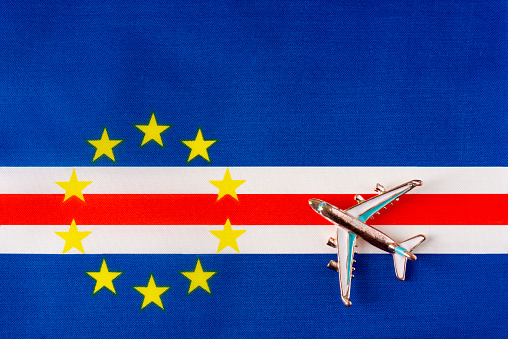 Plane over Cape Verde flag travel concept. Toy plane on a flag in the background.
