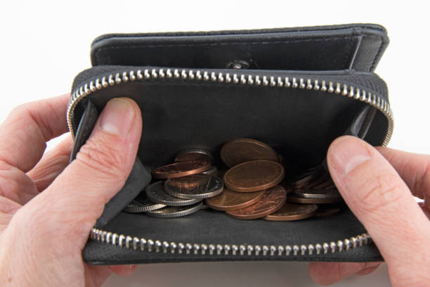 istock Hands hold open purse with only few coins inside 1220360434
