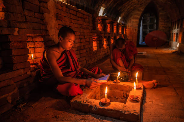 istock Novice buddhist monks contemplating inside temple, Myanmar 1220363494