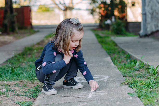 istock Child drawing whit chalk outdoors 1220364217