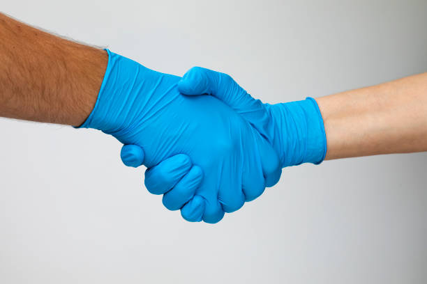 istock People shaking hands with latex gloves 1220364410