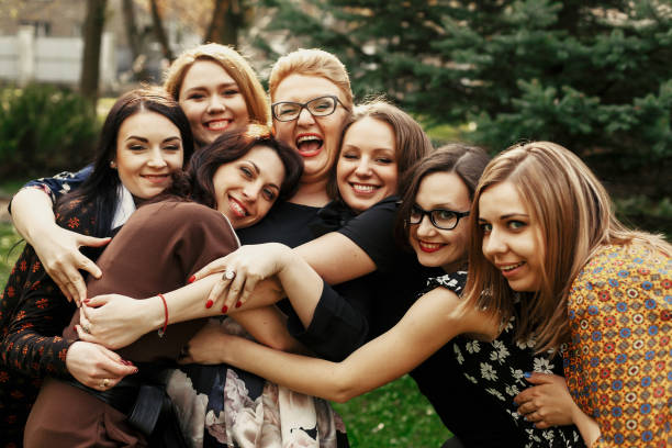 mujeres elegantes y elegantes que se divierten en la celebración en el parque soleado, concepto de momento divertido, reuniéndose - wedding reception bridesmaid wedding party fotografías e imágenes de stock