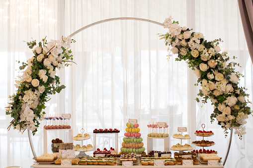 Delicious cake pops, cupcakes, macarons and other sweets on table
