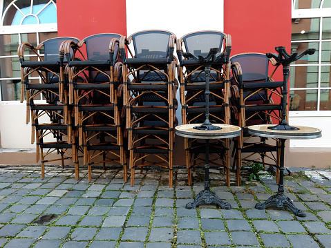 Stacked chairs of a closed outdoor restaurant.