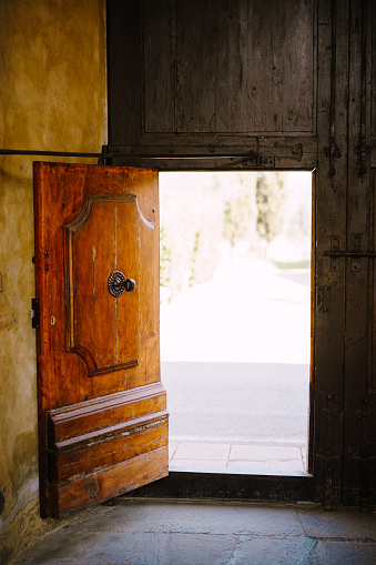 Old wooden door open from the insifr at the Medici Villa of Lilliano Wine Estate, Tuscany, Italy.