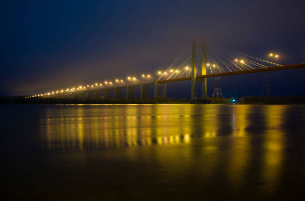 istock Illuminated Suspension Bridge Over River In City At Night 1220370046