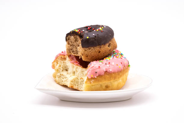 istock isolated delicious donuts on a white background. donut with bite. donut on heart shaped plate. 1220370908