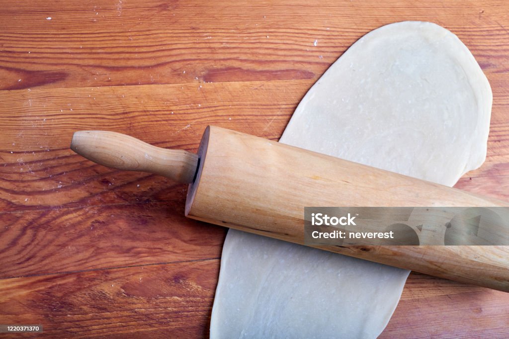 Rolling pin and pasta dough Rolling pin and pasta dough on a wooden kitchen board Bakery Stock Photo