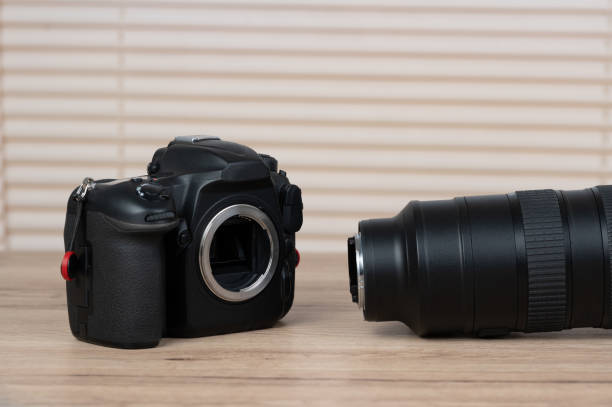 istock Dlsr digital camera and black lens placed on a wooden table 1220375932