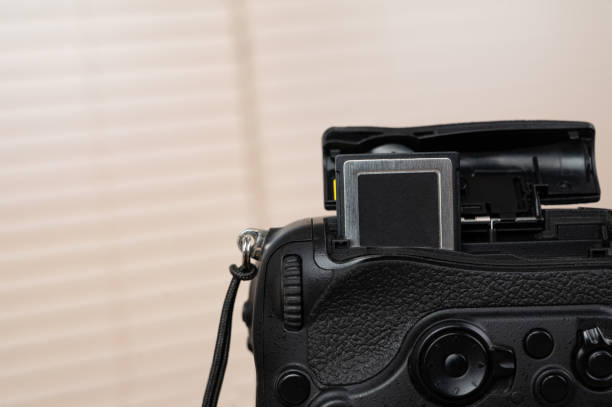 istock memory card, digital camera, dslr and body black camera placed on a wooden table 1220376091