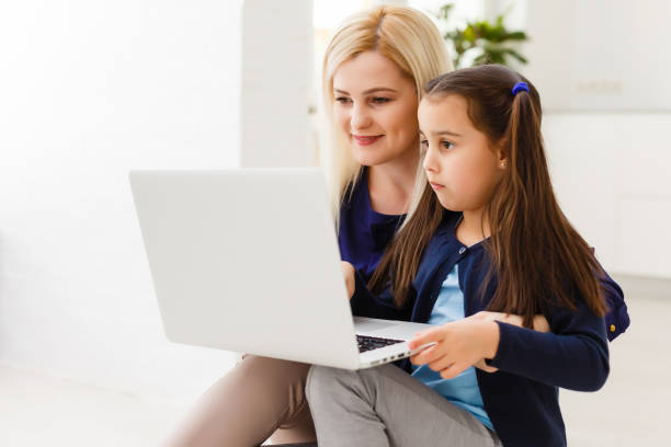 istock Beautiful woman helping her daughter doing her homework in a kitchen 1220378418