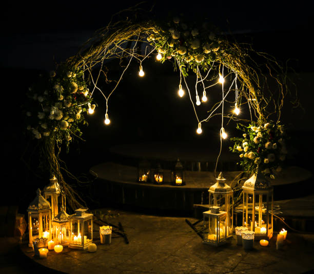 istock White flowers arch at the wedding ceremony. Outdoors decoration. Romantic rustic style. Lamps lights in the evening. 1220378578