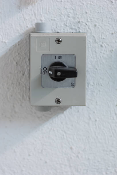 istock Small square electric switch box with on off markings set on a wall close up shot front view 1220382442