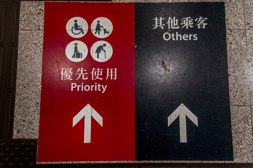 Bilingual and pictorial sign informing in Hong Kong's subway.