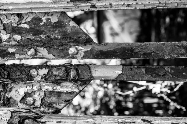 Close up of a rusted metal gate with paint flaking off it.  Selective focus.  Belfast, Northern Ireland.