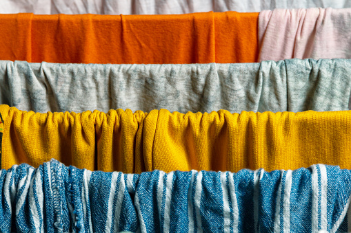 Washed colored textile clothing on the clothes dryer. close up