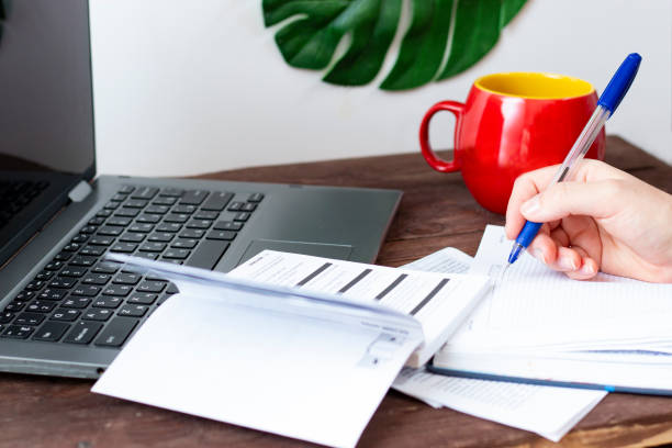 istock Notebook and notepad for notes on a dark wooden table. A young woman holds a ballpoint pen in her hand. The concept of remote work and self-study at home in quarantine. 1220383629