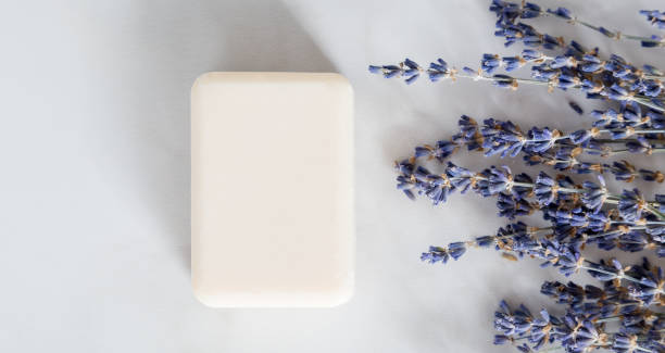 istock Flat lay composition with lavender flower and soap on white marble background. Concept natural hand made product, minimal, copy space, top view 1220385307