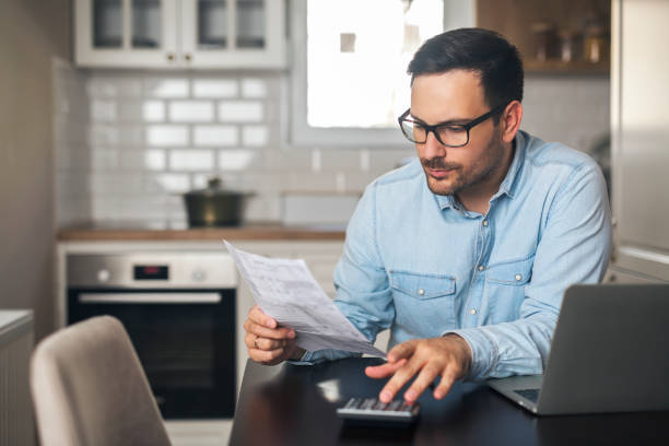 istock Young businessman work at home and counting on a calculator. 1220386055