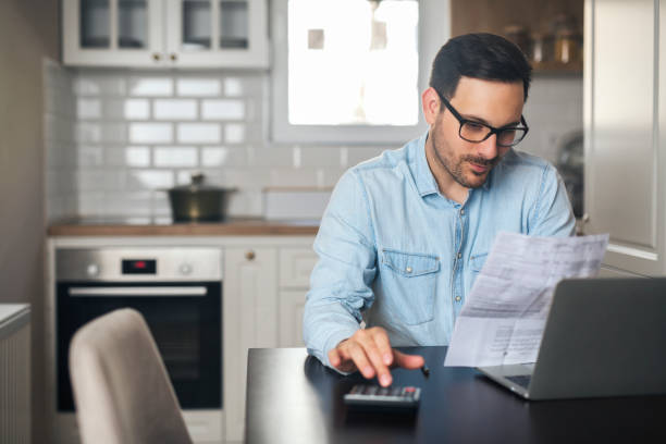 istock Young businessman work at home and counting on a calculator. 1220386058