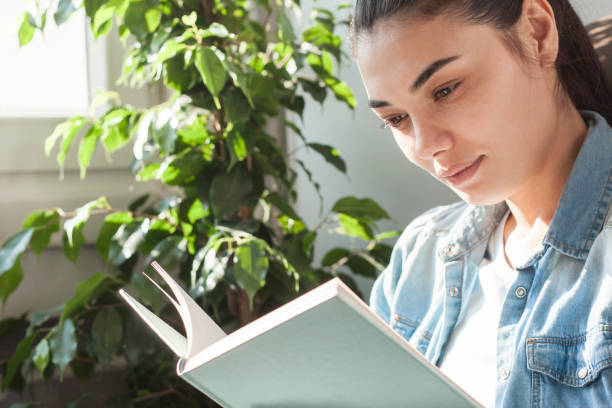 istock young woman reading book at quarantine 1220388215