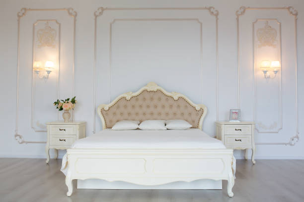 istock Bedroom in soft light colors. Big comfortable double bed in elegant classic bedroom 1220389481