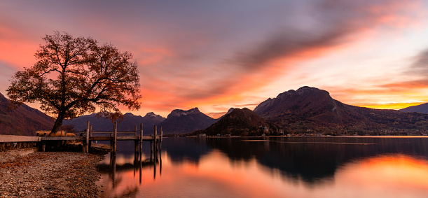 Spectacular sunset in Annecy. Orange and red clouds and a lake in the French Alps