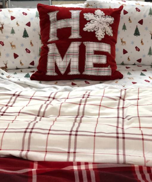 Comfortable bed with red and white decor Warm and inviting cozy bed with Christmas holiday themed decor red cushion covers stock pictures, royalty-free photos & images