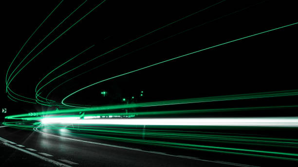 green car lights at night. long exposure - speed horizontal commercial land vehicle automobile industry imagens e fotografias de stock