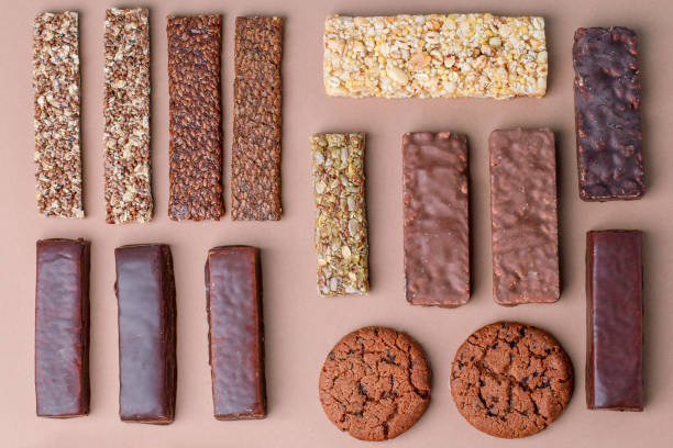 istock Different Energy protein bars and oatmeal bars on light brown chocolate background. Set of energy, sport, breakfast and protein bars. Copy space. Flat lay 1220393011