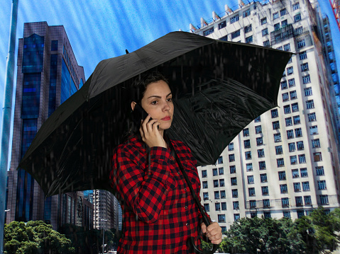 woman with umbrella in urban landscape with buildings in the background