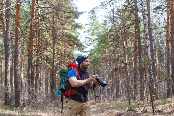 istock Bird watcher walks through the woods with a camera. 1220395864