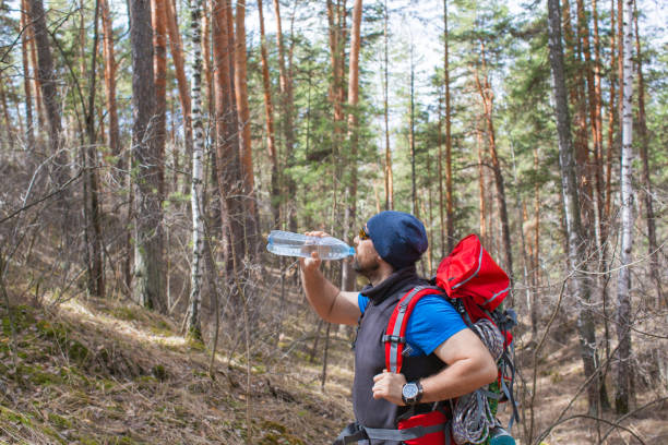 istock Tourist drinks water from a bottle in the forest. 1220395887