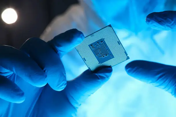 Photo of Hands in gloves hold chip testing microelectronics