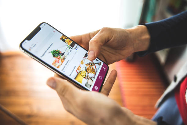 Woman ordering food by mobile app delivery at home at social distancing time Woman ordering food by mobile app delivery at home at social distancing time ordering stock pictures, royalty-free photos & images