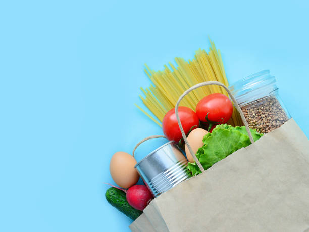 istock The main food: buckwheat, pasta, tomatoes, cucumbers, flying on a bare background. Quarantine coronavirus. Set of quarantine food, concept, cardboard box, close-up. Food delivery home, food donation. 1220396331