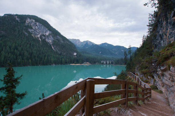 istock Dirt path to staircase runs along the Braies Lake under a cloudy sky 1220396548
