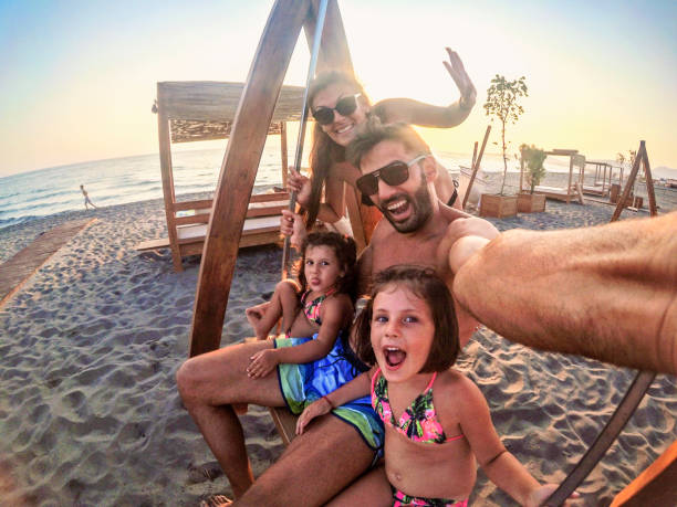 istock Young Family play on the beach swing 1220397047