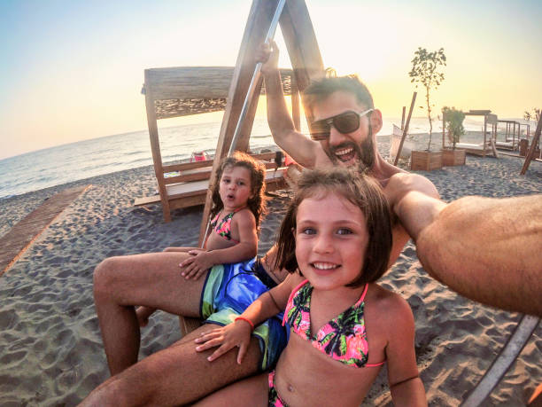 istock Young Family play on the beach swing 1220397899