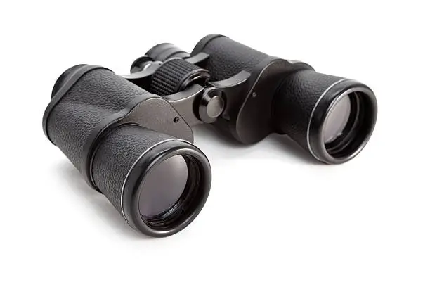 Photo of A lone pair of black binoculars on a white background