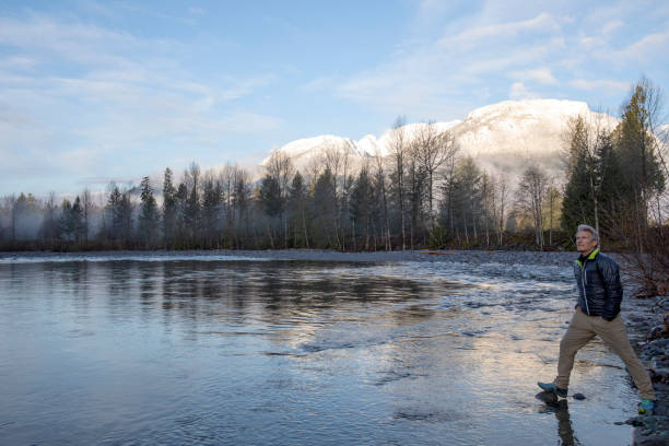 istock Man relaxes by lake at sunrise 1220399942