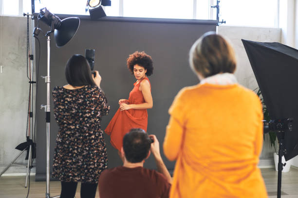istock Three attendees  standing in studio and taking photos of beautiful mixed race female model. 1220400106