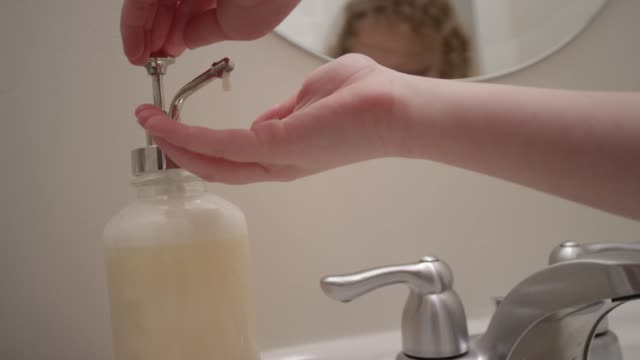Close up of hand pressing out liquid hand soap in slow motion