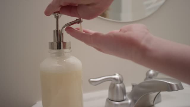Close up of hand pressing out liquid hand soap in slow motion