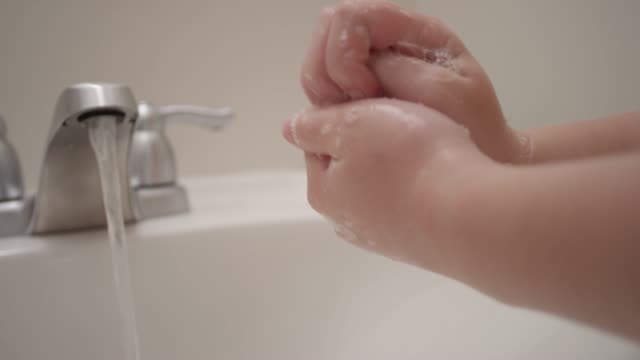 Close up of hands scrubbing thoroughly and making soap bubbles in slow motion