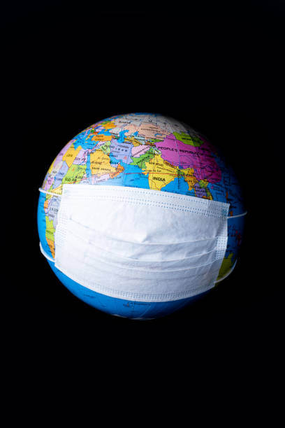 istock Earth globe model with antiviral surgical protective face mask over black background. Protect earth planet concept. 1220404203