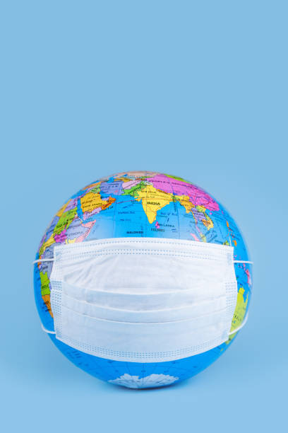 istock Earth globe model with antiviral surgical protective face mask over blue background. Protect earth planet concept. 1220404214