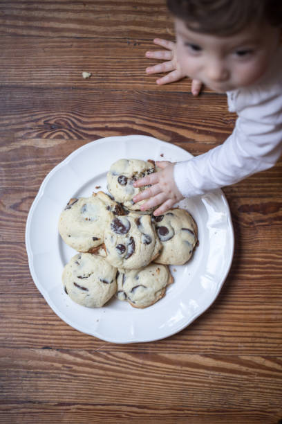 istock Baby grabbing a cookie from the plate 1220405987