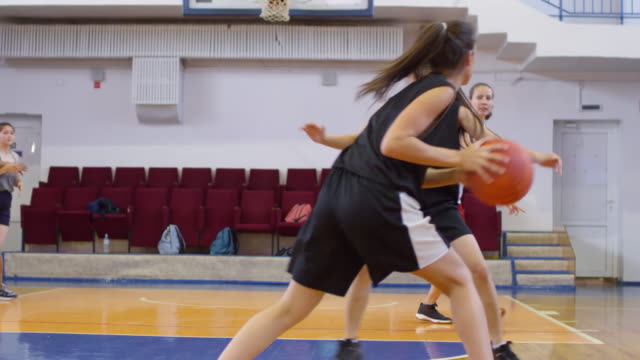 Multiethnic Girls Playing Basketball on Indoor Court